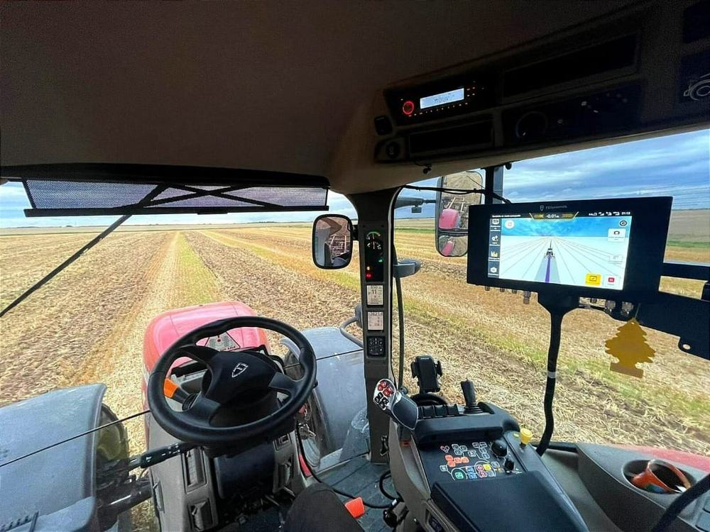 Piloto automático instalado na cabine de um trator, com monitor mostrando a linha de passada
